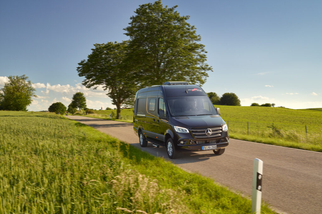 Malibu Genius 641 Le in obsidianschwarz Fahraufnahme auf einer schönen Landstraße