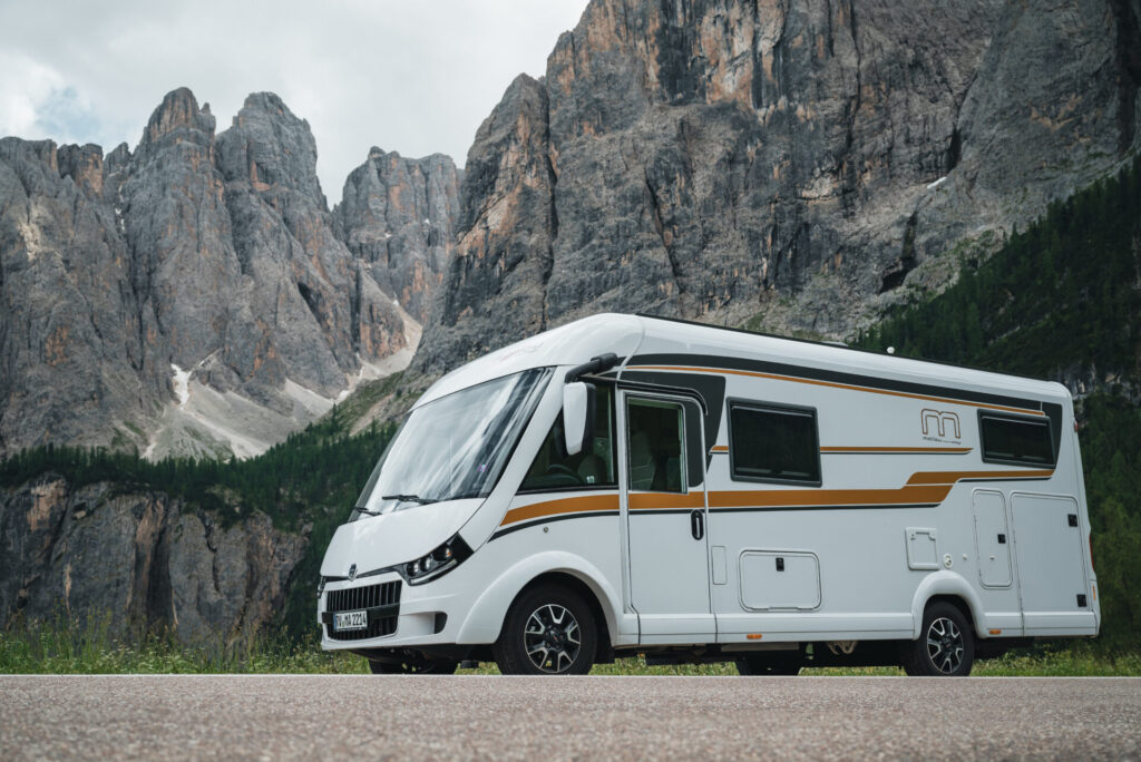 Vollintegriertes Malibu Wohnmobil umgeben von Gebirge.