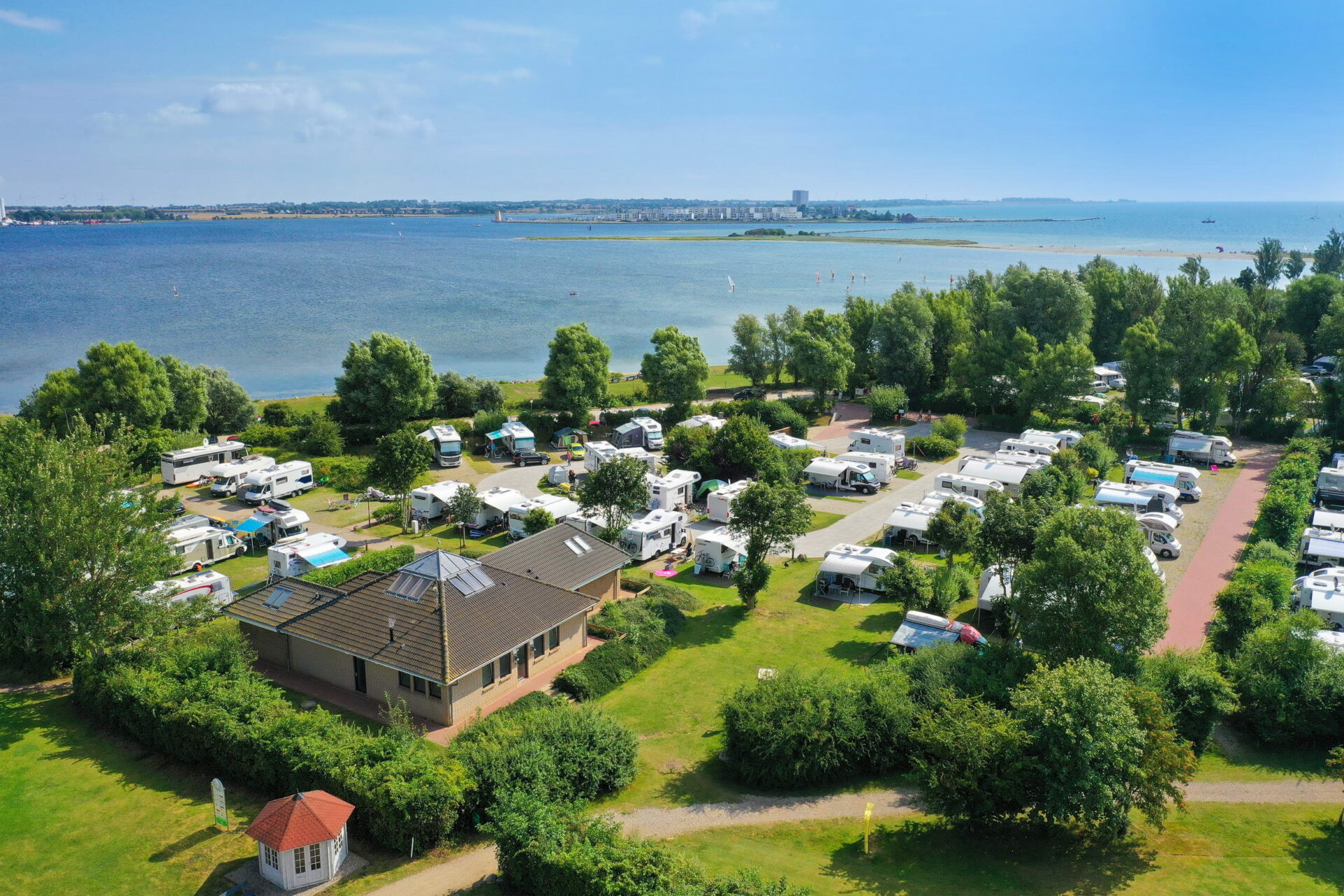 Campingplatz im Grünen mit einigen Wohnmobilen direkt am See