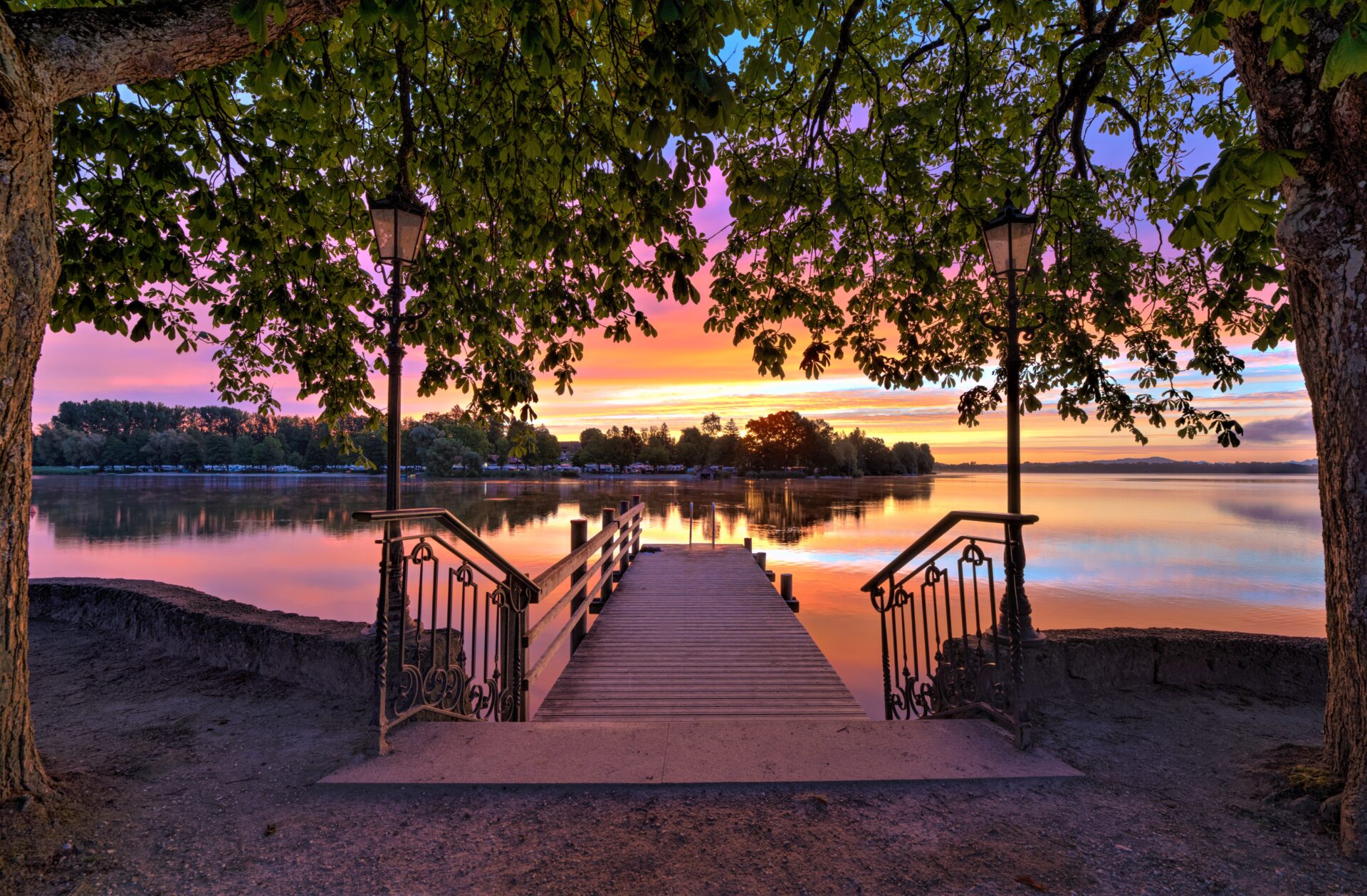 Ein Steg, der über das Wasser führt bei Sonnenuntergang.