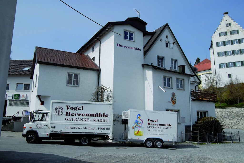 Ein LKW, bedruckt mit dem Logo der Vogel Herrenmühle, steht vor der Kleinmühle in Aulendorf.