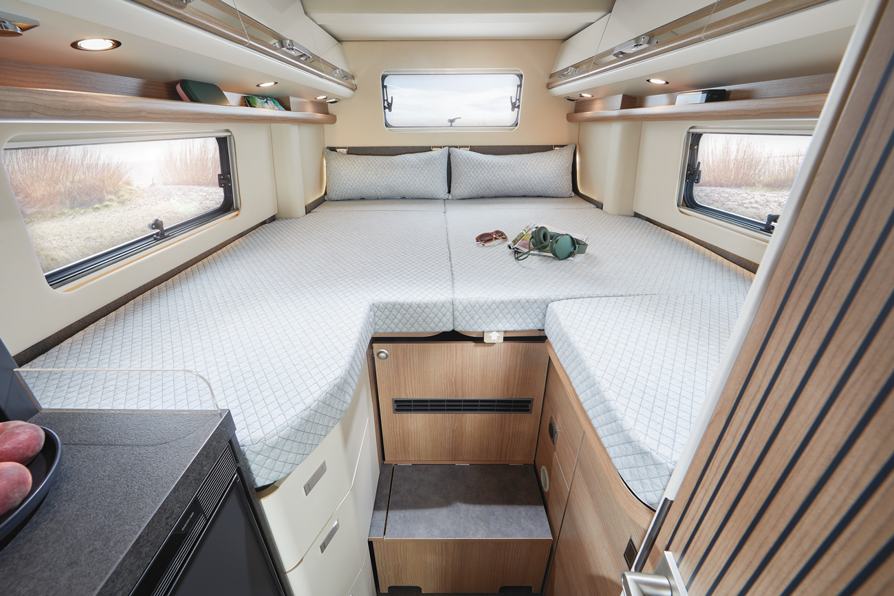 Haupt-Schlafbereich des Malibu Genius 641 LE, ausgestattet mit einem großzügigen Bett, weichen Kissen und moderner Beleuchtung, der eine komfortable und luxuriöse Schlafumgebung bietet