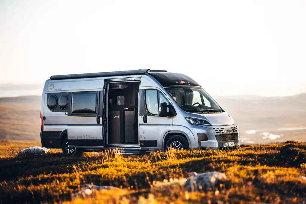 Seitenansicht eines Malibu Campervans inmitten einer baumlosen, steinigen herbstlichen Landschaft.