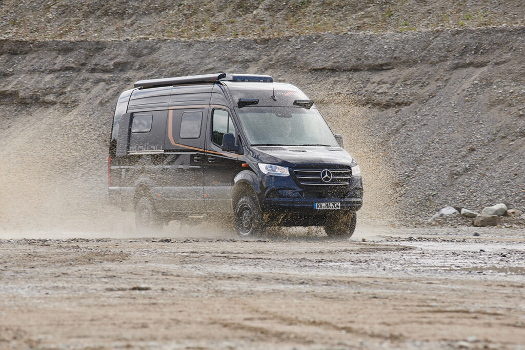 Malibu Genius 4x4 Performance, unterwegs auf einer Schotterpiste, zeigt seine Offroad-Fähigkeiten und das sportliche, robuste Design in einer natürlichen Umgebung