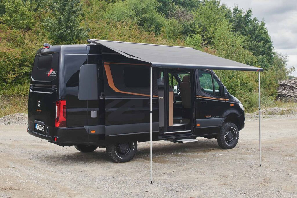 Malibu Genius 4x4 Performance, geparkt in einer sonnigen Waldlichtung, präsentiert die Dachmarkise des Fahrzeugs, perfekt für Natur- und Outdoor-Abenteuer.