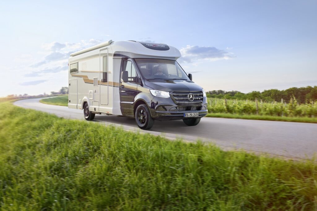 Malibu Reisemobil Teilintegriert fährt auf einer Landstraße.